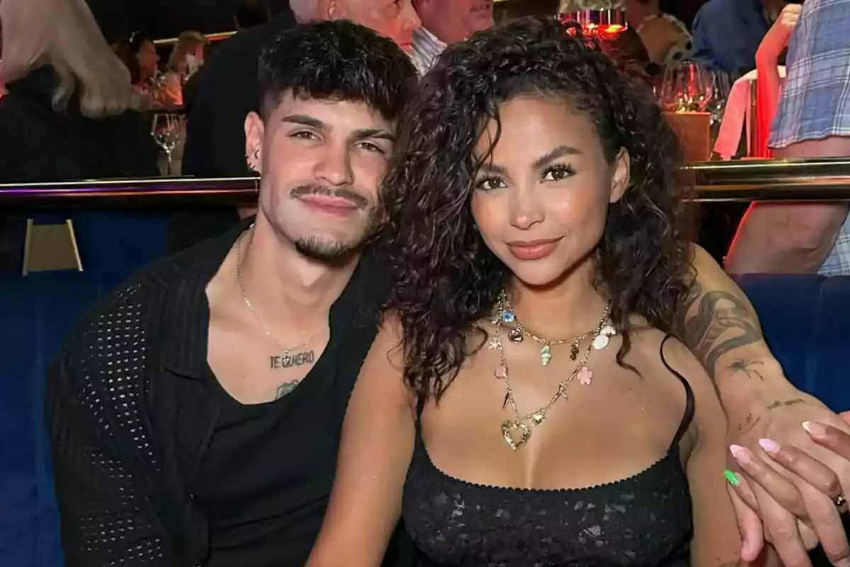 Álvaro i Mayeli asseguts en un restaurant elegant somriuen mentre posen junts per a la foto Álvaro i Mayeli asseguts en un restaurant elegant somriuen mentre posen junts per a la foto