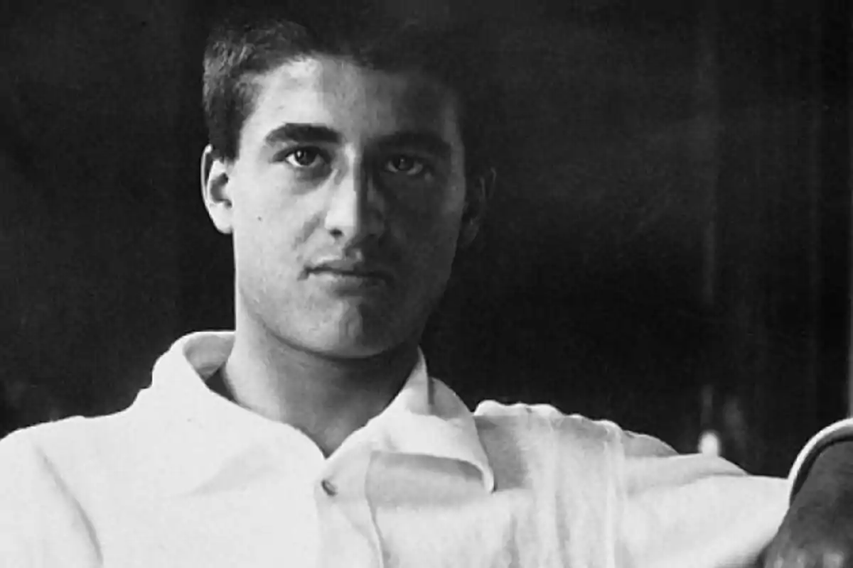 Jove amb cabell curt i camisa clara mirant a la càmera en una fotografia en blanc i negre Jove amb cabell curt i camisa clara mirant a la càmera en una fotografia en blanc i negre