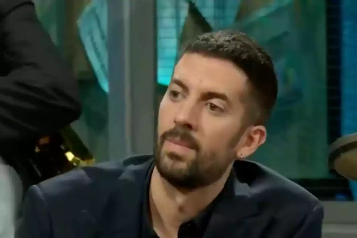David Broncano amb barba curta i cabell fosc assegut a 'La Revuelta' amb expressió seriosa