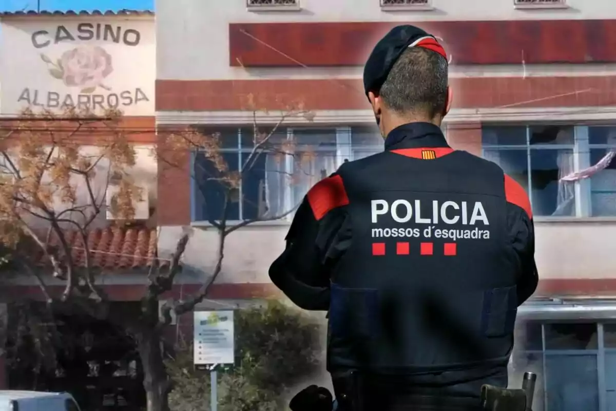 Un agent dels Mossos d'Esquadra d'esquena davant d'un edifici amb el rètol Casino Albarrosa