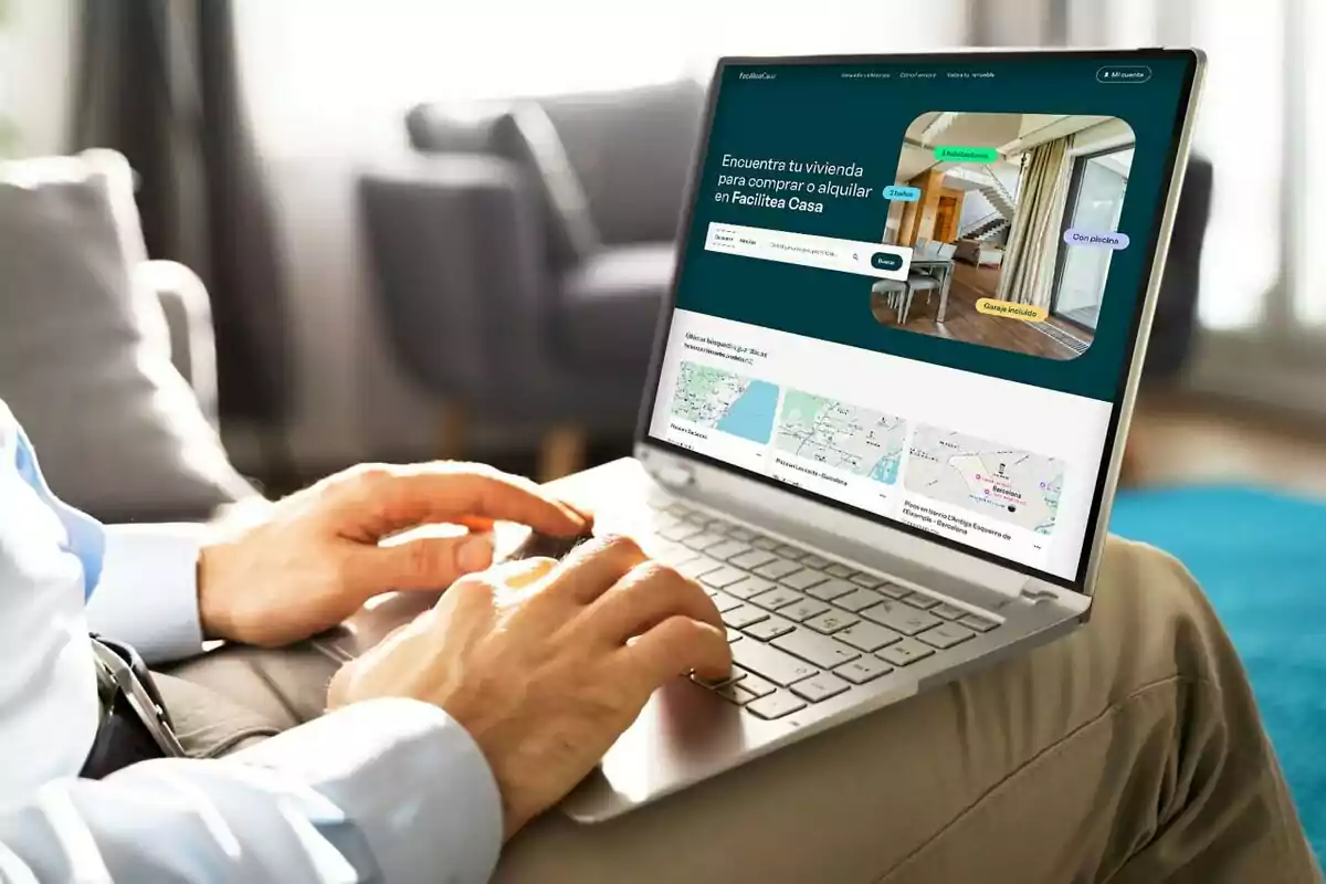 Persona utilitzant un portàtil per buscar habitatges en una pàgina web immobiliària