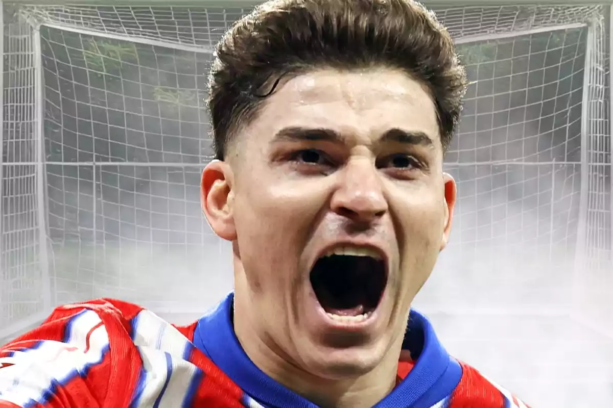 Soccer player celebrating a goal with an expression of euphoria in front of a goal