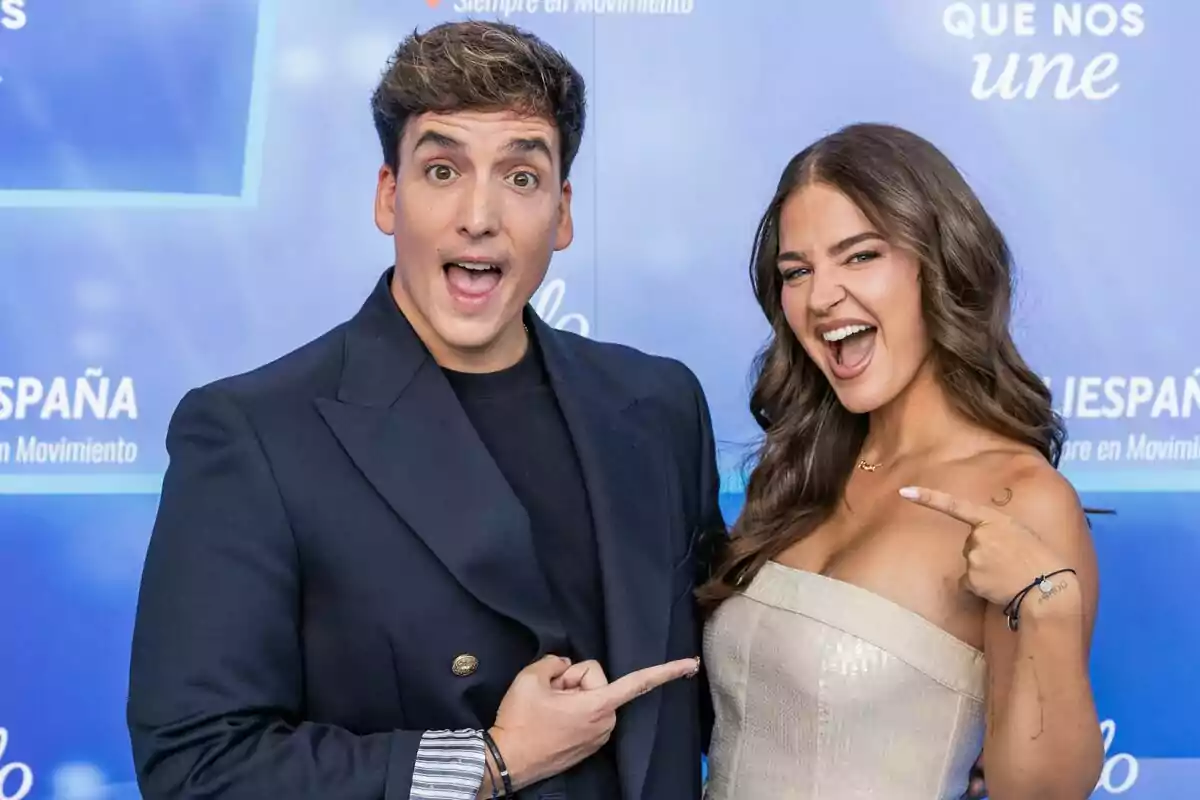 Xuso Jones i Laura Escanes somriuen i es senyalen mútuament davant d’un fons blau en un esdeveniment de Mediaset Xuso Jones i Laura Escanes somriuen i es senyalen mútuament davant d’un fons blau en un esdeveniment de Mediaset