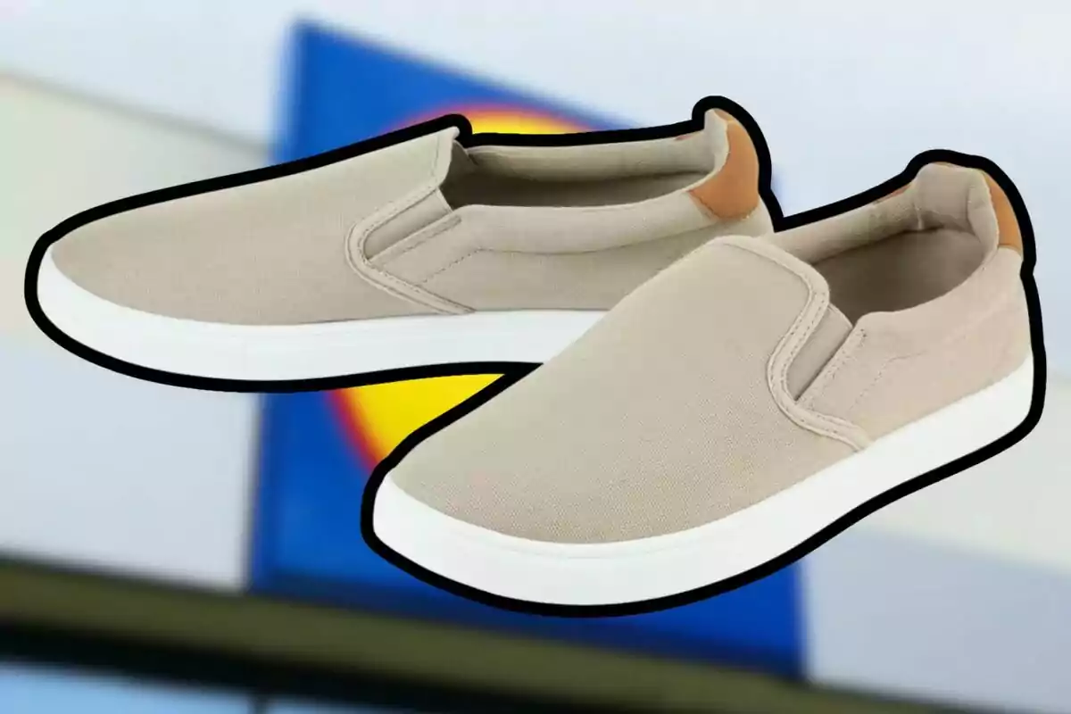 A pair of beige slip-on sneakers with a white sole and a brown detail on the heel, set against a blurred background with blue and yellow colors. A pair of beige slip-on sneakers with a white sole and a brown detail on the heel, set against a blurred background with blue and yellow colors.