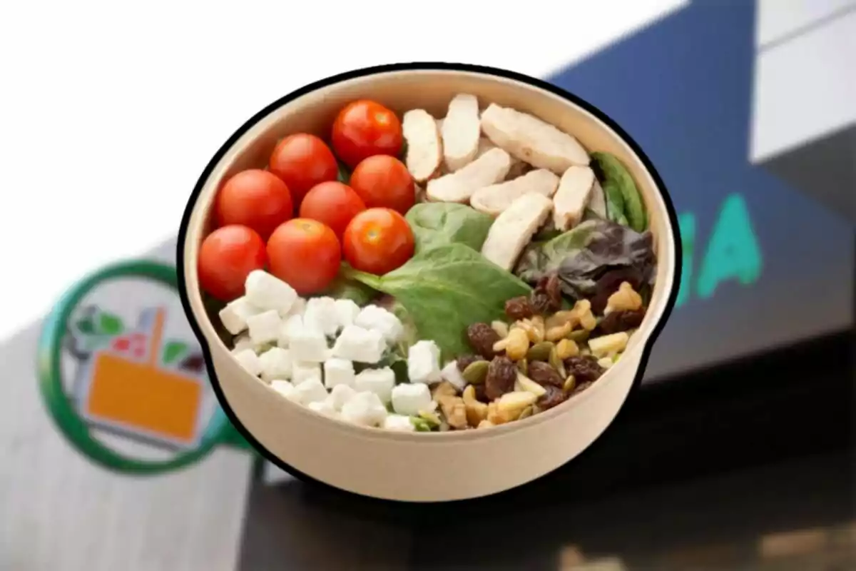 Salad in a cardboard container with cherry tomatoes, chicken, spinach, cheese, and nuts in front of a store Salad in a cardboard container with cherry tomatoes, chicken, spinach, cheese, and nuts in front of a store