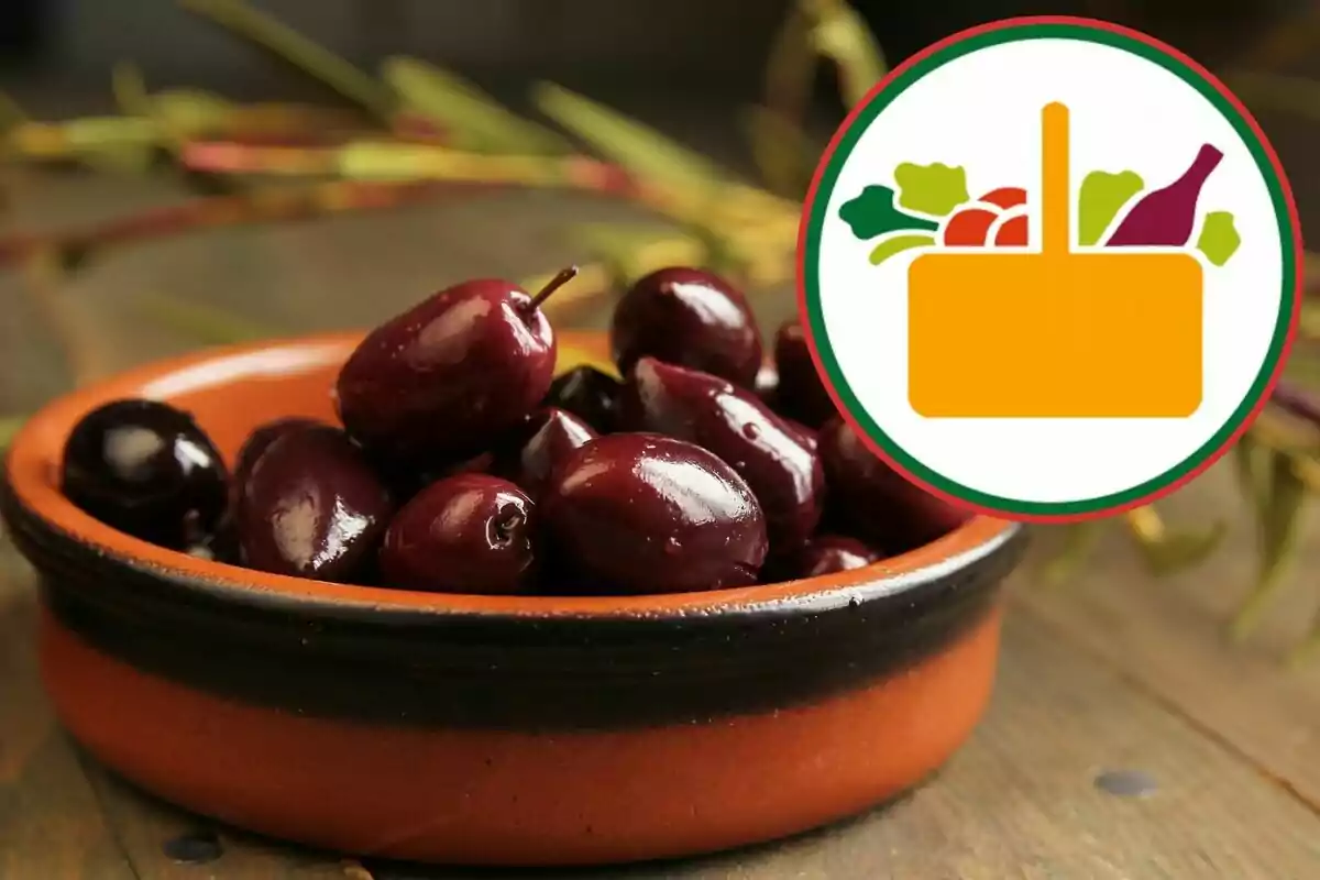 Black olives on a clay plate with a food basket logo in the top right corner Black olives on a clay plate with a food basket logo in the top right corner