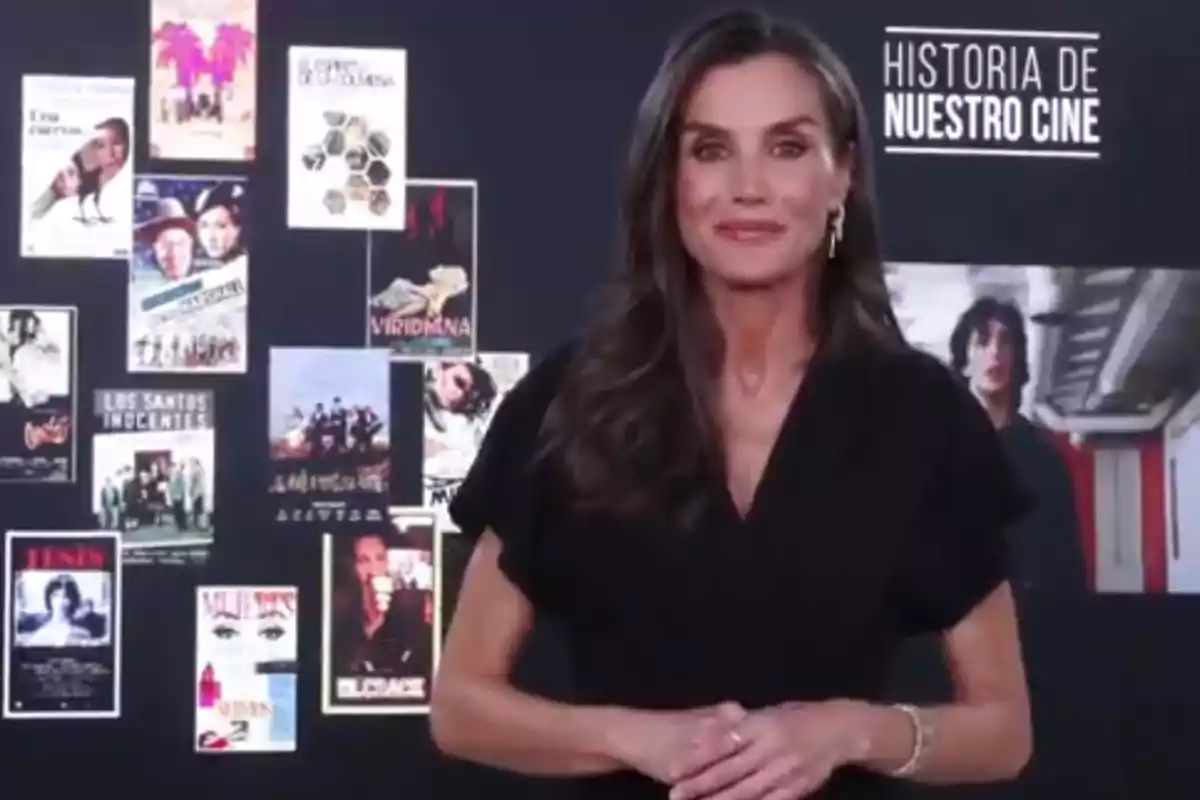 La reina Letícia, vestida de negre, posant davant d’un fons amb cartells de pel·lícules per felicitar el programa ‘Història del nostre cinema’.
