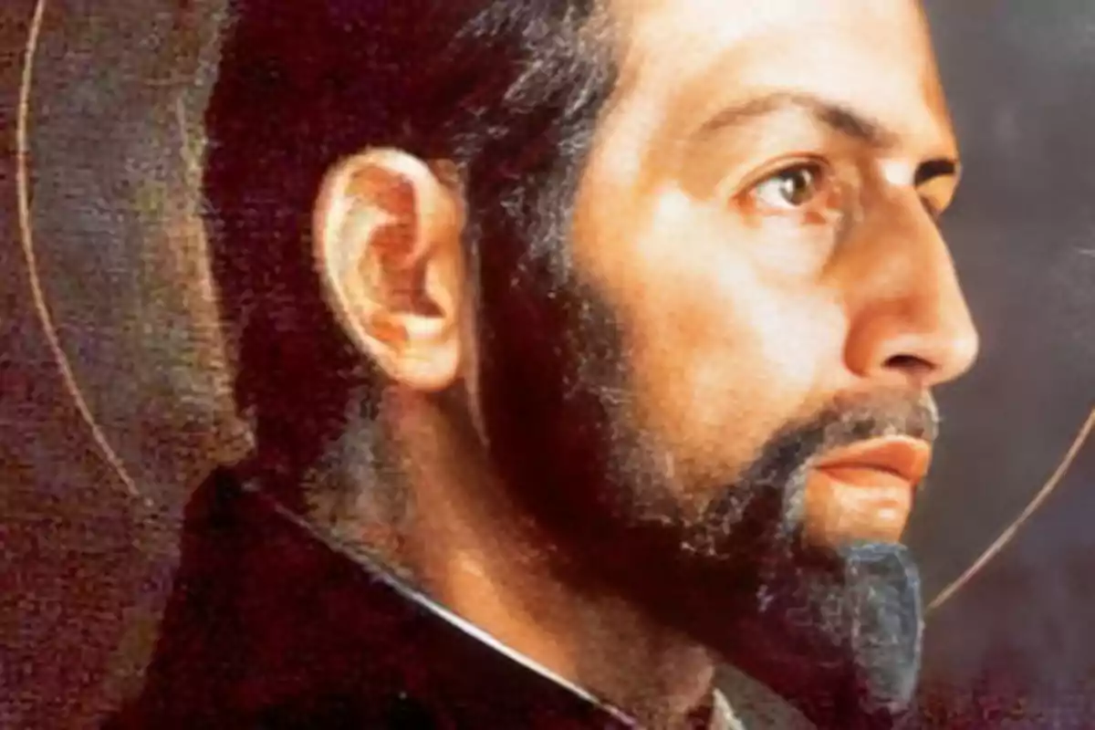 Retrat d’un home amb barba curta i halo daurat sobre fons fosc