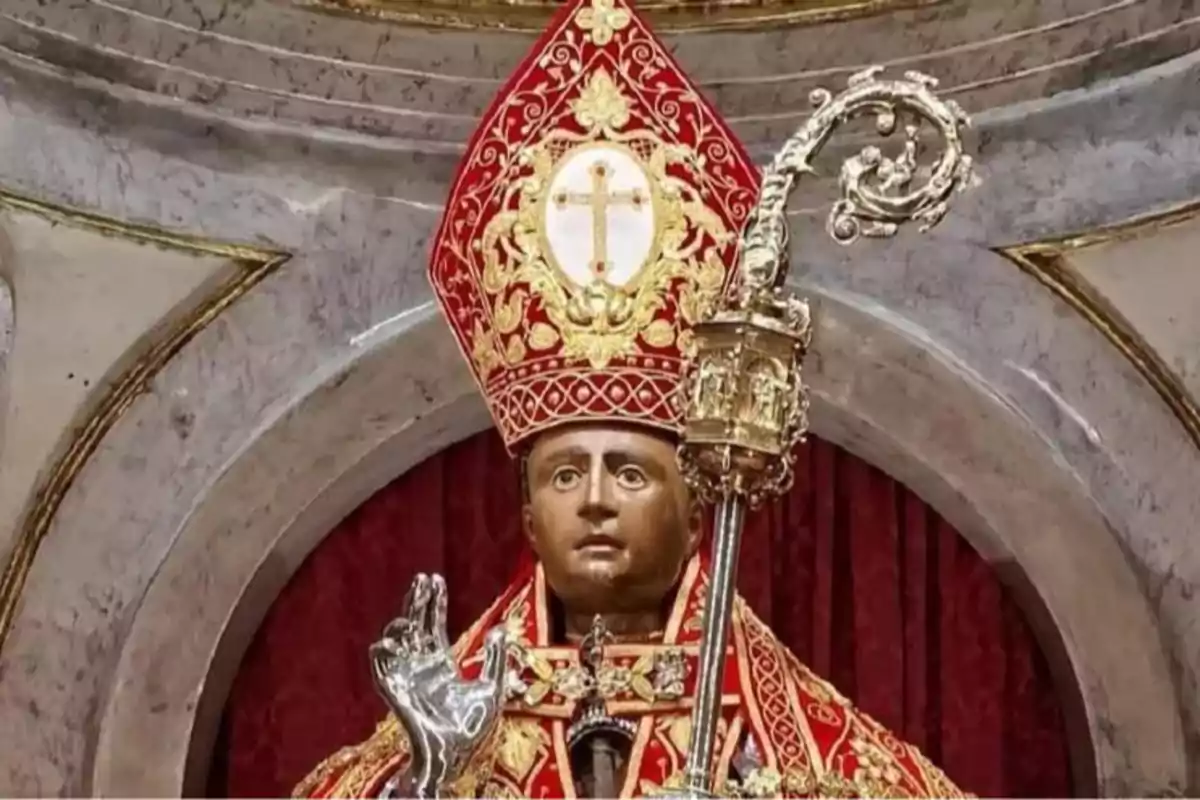 Estàtua religiosa d’un bisbe amb vestimenta vermella i daurada, mitra decorada i bàcul a la mà Estàtua religiosa d’un bisbe amb vestimenta vermella i daurada, mitra decorada i bàcul a la mà