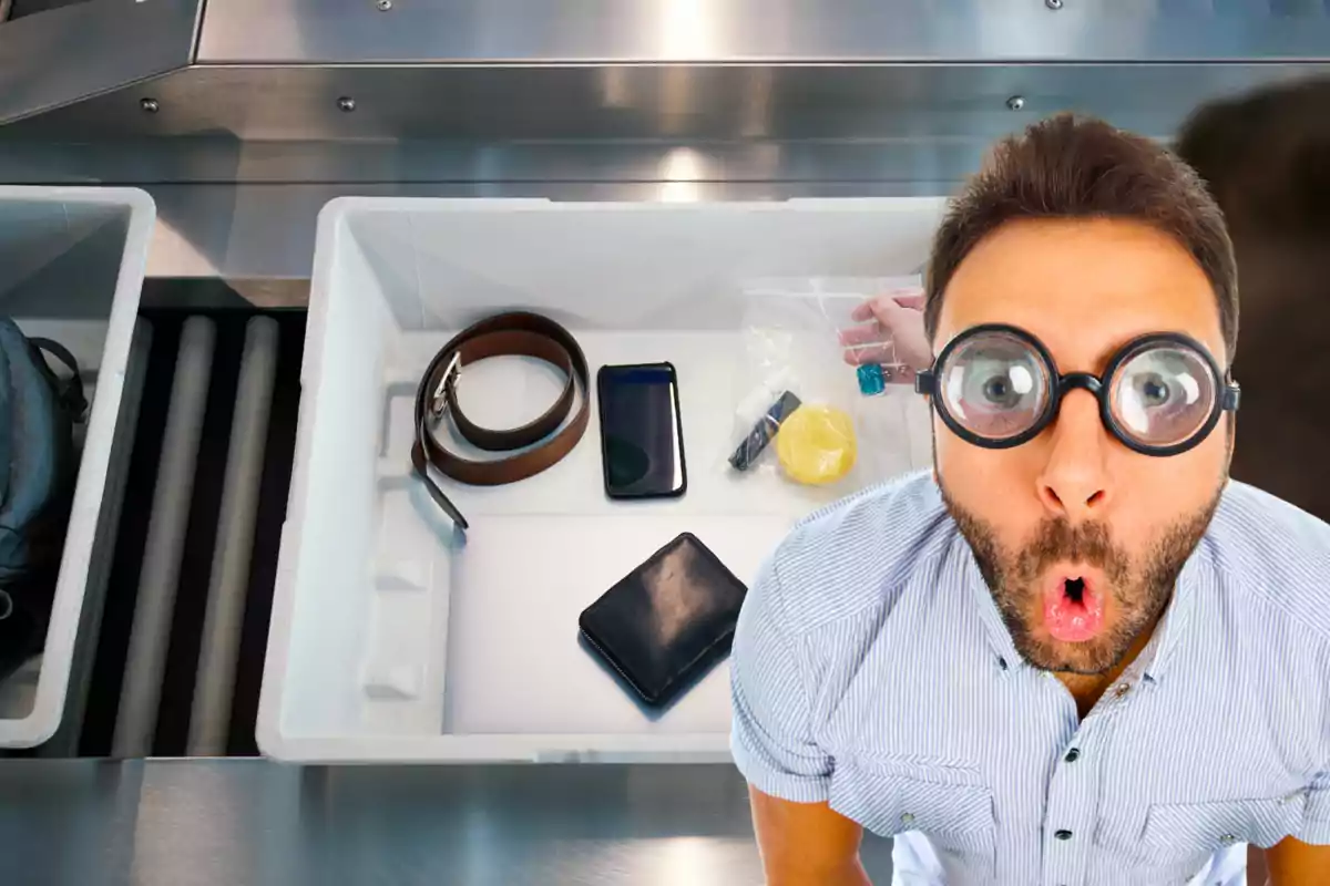 Hombre con gafas grandes y expresión de sorpresa junto a una bandeja de control de seguridad en el aeropuerto con objetos personales como cinturón, teléfono, cartera y líquidos. Hombre con gafas grandes y expresión de sorpresa junto a una bandeja de control de seguridad en el aeropuerto con objetos personales como cinturón, teléfono, cartera y líquidos.