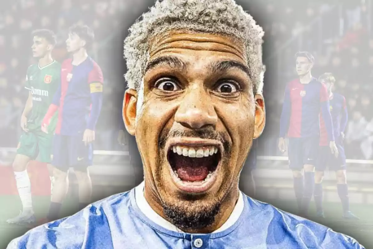 Man with platinum blonde hair and a surprised or excited expression in the foreground, with a blurred background of players in a stadium