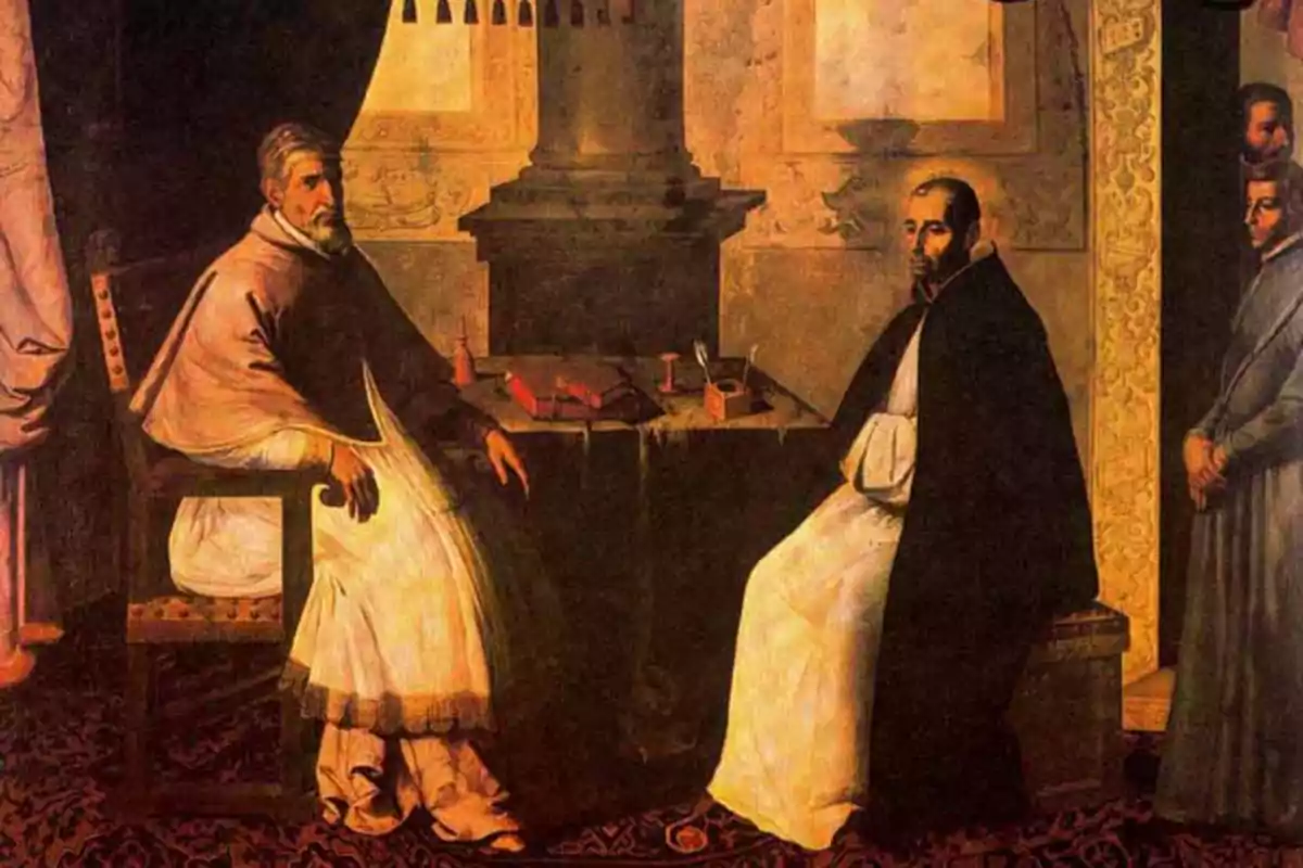 Dos hombres con vestimenta religiosa sentados frente a una mesa en una habitación con decoración antigua mientras otras personas observan al fondo Dos hombres con vestimenta religiosa sentados frente a una mesa en una habitación con decoración antigua mientras otras personas observan al fondo
