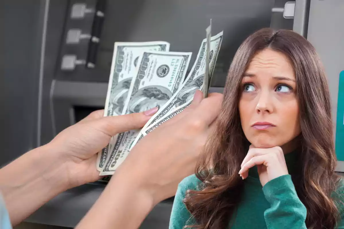 Woman with a worried expression while someone counts hundred-dollar bills in front of an ATM Woman with a worried expression while someone counts hundred-dollar bills in front of an ATM