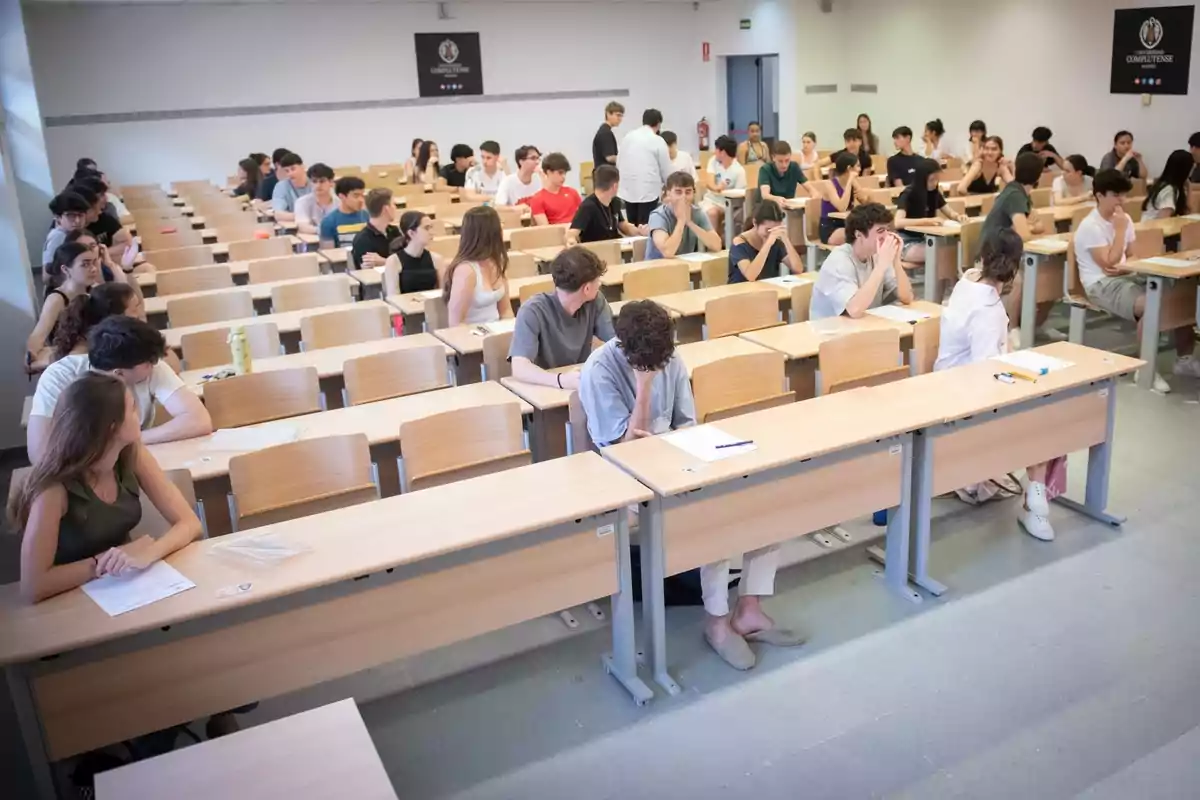 Una aula plena d'estudiants asseguts en escriptoris individuals esperant l'inici d'un examen Una aula plena d'estudiants asseguts en escriptoris individuals esperant l'inici d'un examen