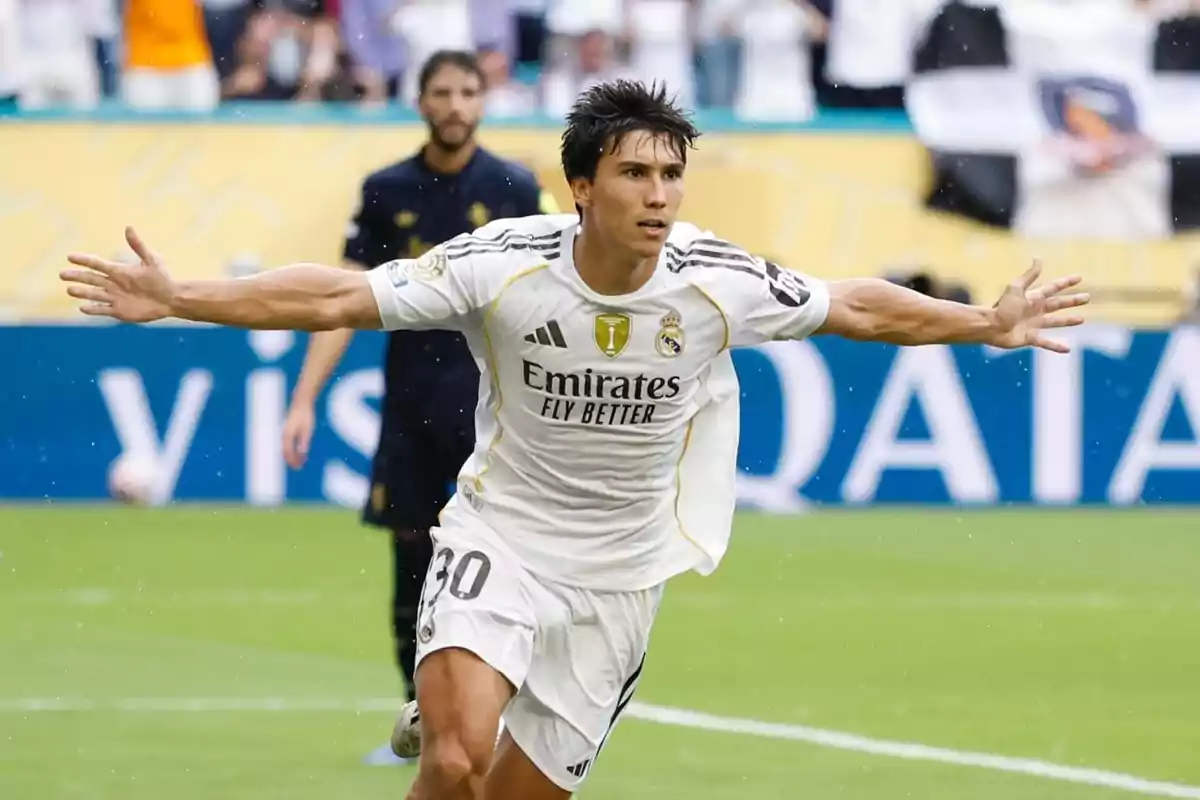 Futbolista del Reial Madrid celebrant un gol amb els braços estesos en un estadi durant un partit Futbolista del Reial Madrid celebrant un gol amb els braços estesos en un estadi durant un partit