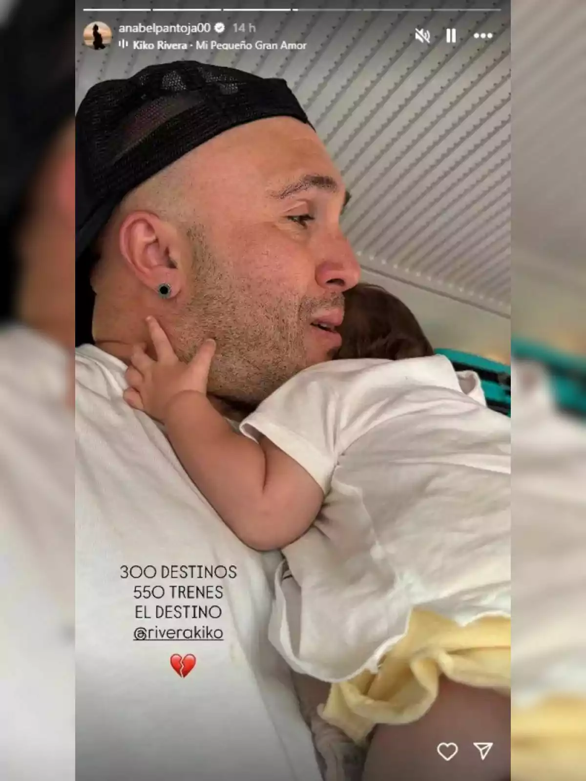 Kiko Rivera wearing a black cap hugging a baby dressed in a white jersey and yellow diaper, both in an indoor setting with a lined ceiling; there is text and a broken heart emoji over the image. Kiko Rivera wearing a black cap hugging a baby dressed in a white jersey and yellow diaper, both in an indoor setting with a lined ceiling; there is text and a broken heart emoji over the image.