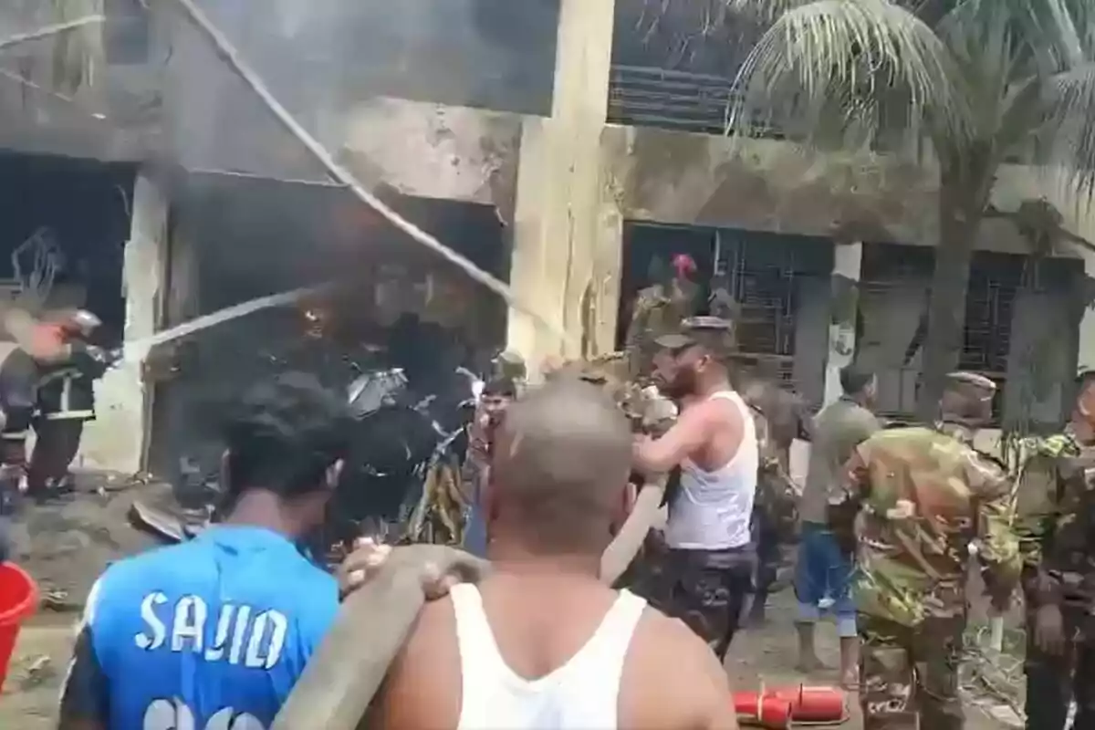 Diverses persones, entre elles bombers i militars, treballen per apagar un incendi en un edifici mentre s’observa fum sortint del lloc. Diverses persones, entre elles bombers i militars, treballen per apagar un incendi en un edifici mentre s’observa fum sortint del lloc.