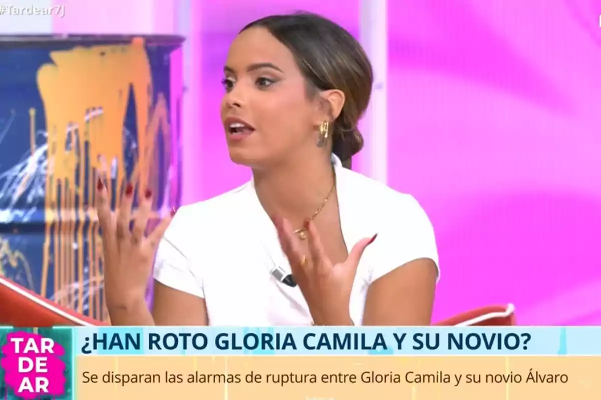 Dona parlant en un programa de televisió amb un fons rosa i un rètol que pregunta sobre la possible ruptura de la Gloria Camila i el seu xicot. Dona parlant en un programa de televisió amb un fons rosa i un rètol que pregunta sobre la possible ruptura de la Gloria Camila i el seu xicot.