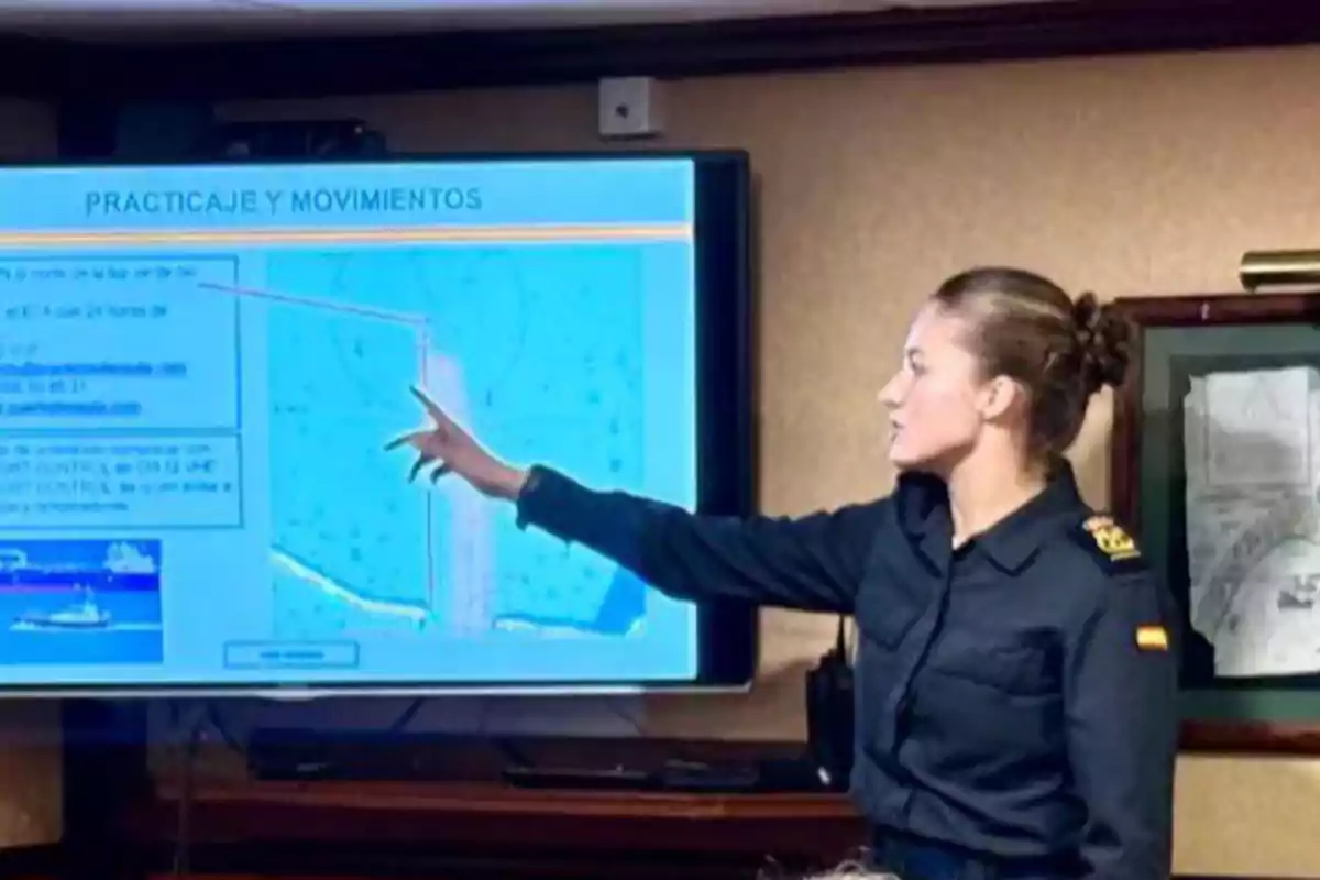 Woman in military uniform pointing at a screen during a presentation on piloting and maritime movements