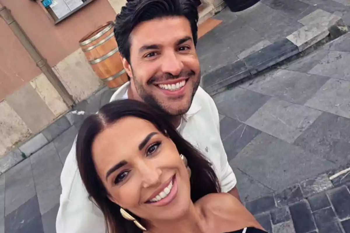 Parella somrient fent-se una selfie a l’aire lliure en un carrer de pedra Parella somrient fent-se una selfie a l’aire lliure en un carrer de pedra