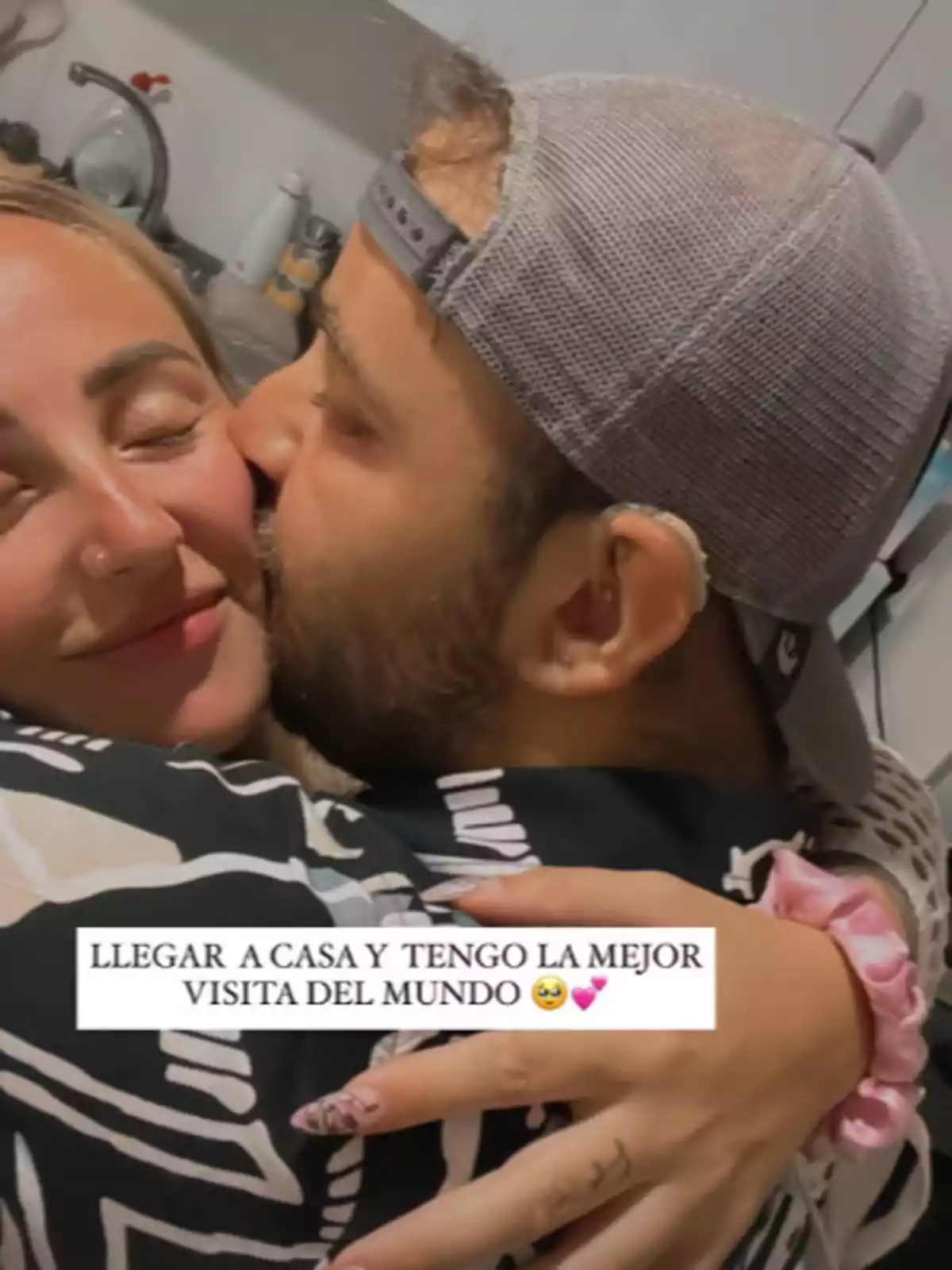 A couple embraces joyfully in a kitchen, as the man kisses the woman's cheek and both smile with their eyes closed, conveying happiness and affection. A couple embraces joyfully in a kitchen, as the man kisses the woman's cheek and both smile with their eyes closed, conveying happiness and affection.