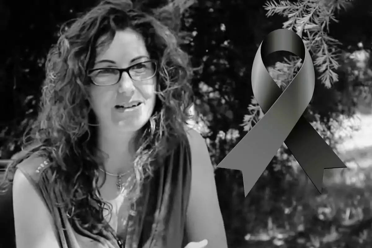Dona de cabells arrissats i ulleres en una imatge en blanc i negre amb un llaç negre de dol al costat