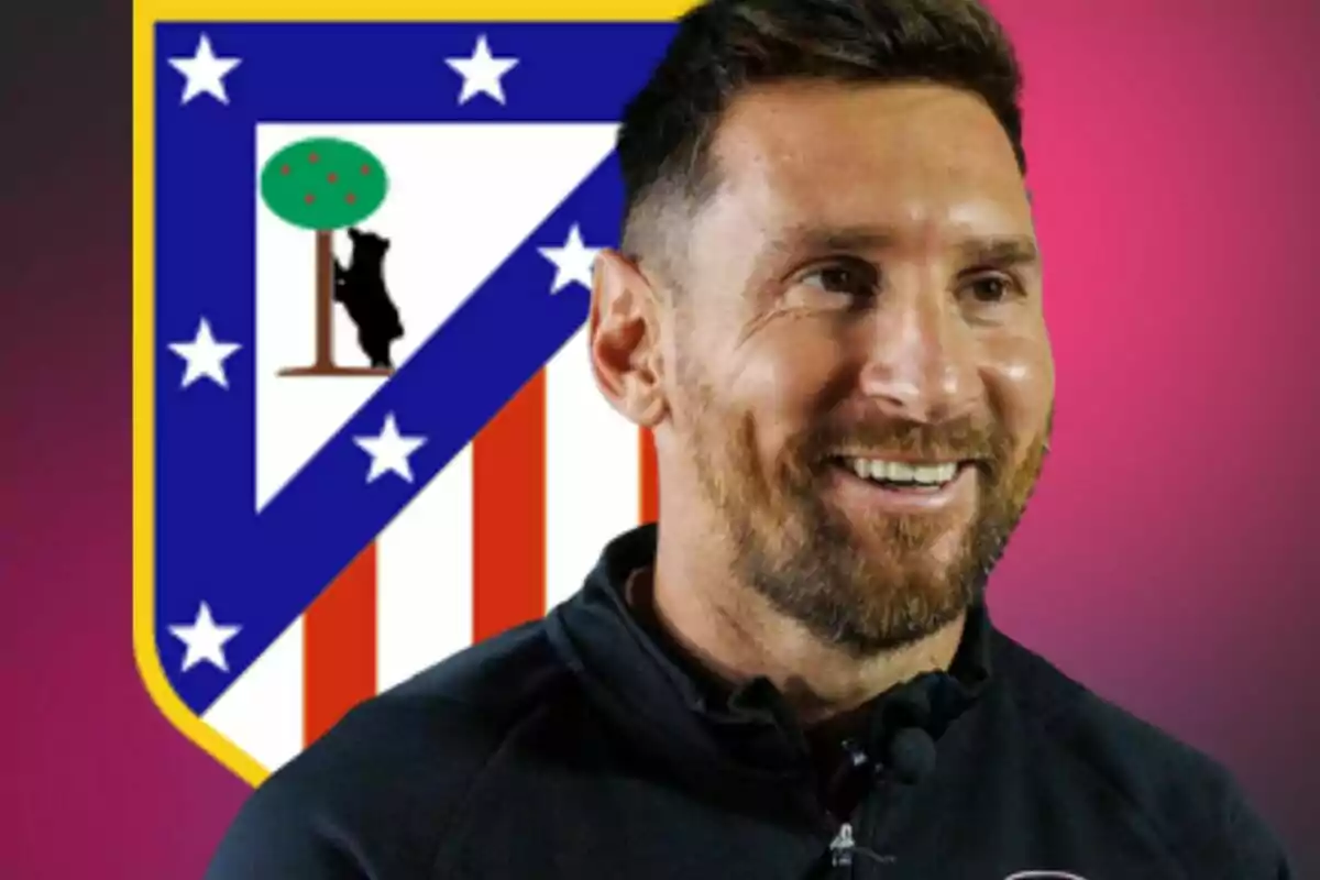 Un home somrient amb barba davant de l'escut de l'Atlètic de Madrid