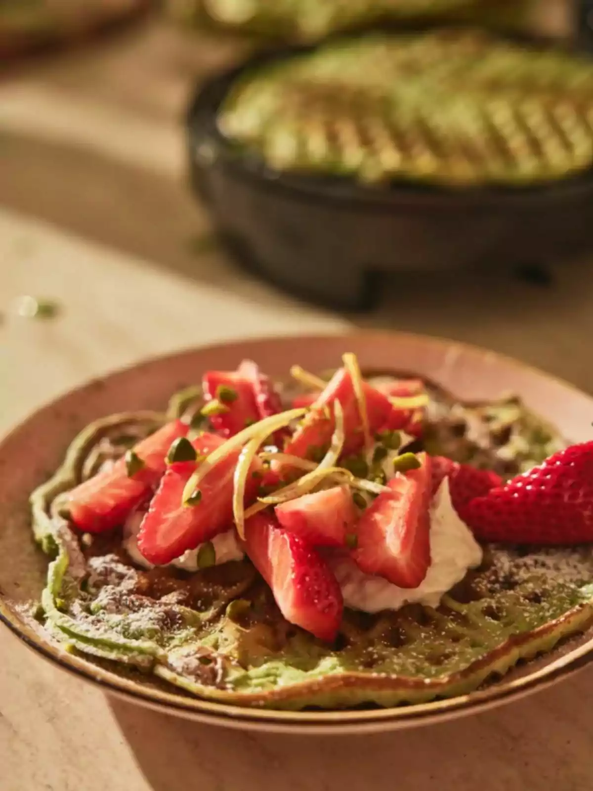 Green waffle served on a plate with whipped cream, fresh strawberries, and lemon zest Green waffle served on a plate with whipped cream, fresh strawberries, and lemon zest