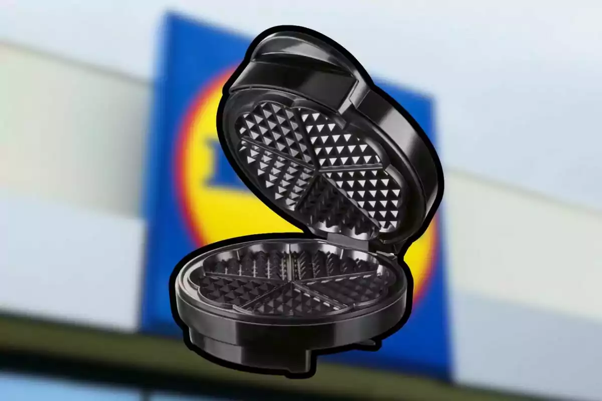 An open black waffle maker with a blurred background of a supermarket sign An open black waffle maker with a blurred background of a supermarket sign