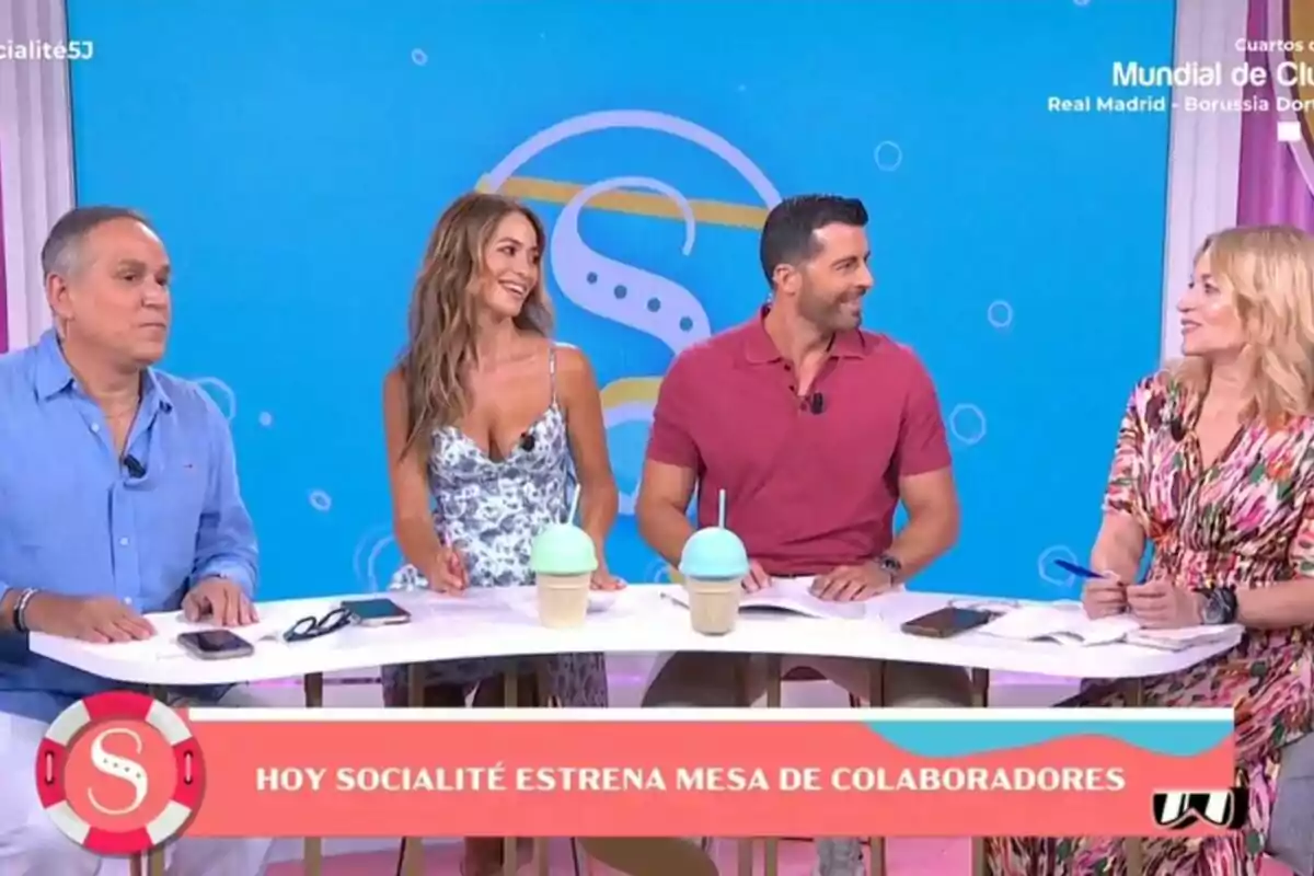 Aurelio Manzano, María Verdoy, Antonio Santana, and Almudena del Pozo sitting at a table on a television show with a blue background and a sign announcing the debut of a new panel of contributors on Socialité. Aurelio Manzano, María Verdoy, Antonio Santana, and Almudena del Pozo sitting at a table on a television show with a blue background and a sign announcing the debut of a new panel of contributors on Socialité.