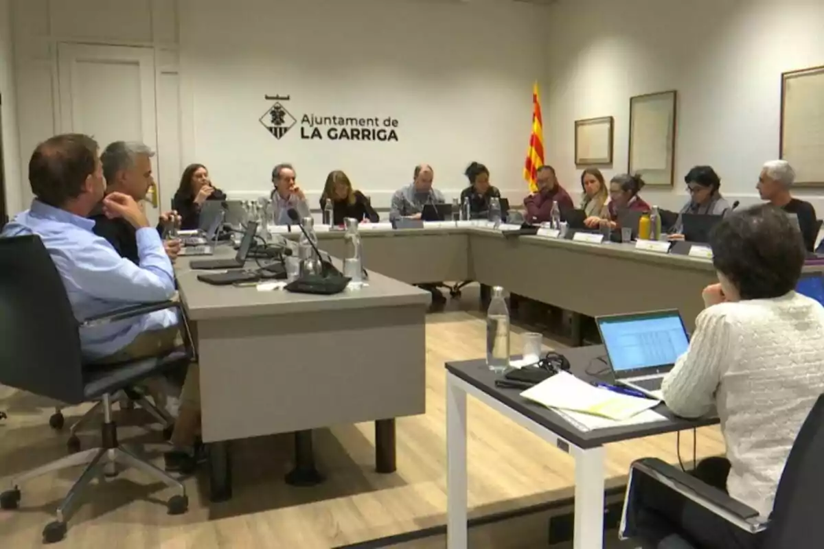 Meeting of several people sitting around a table in a conference room at La Garriga town hall, with laptops and water bottles on the table Meeting of several people sitting around a table in a conference room at La Garriga town hall, with laptops and water bottles on the table