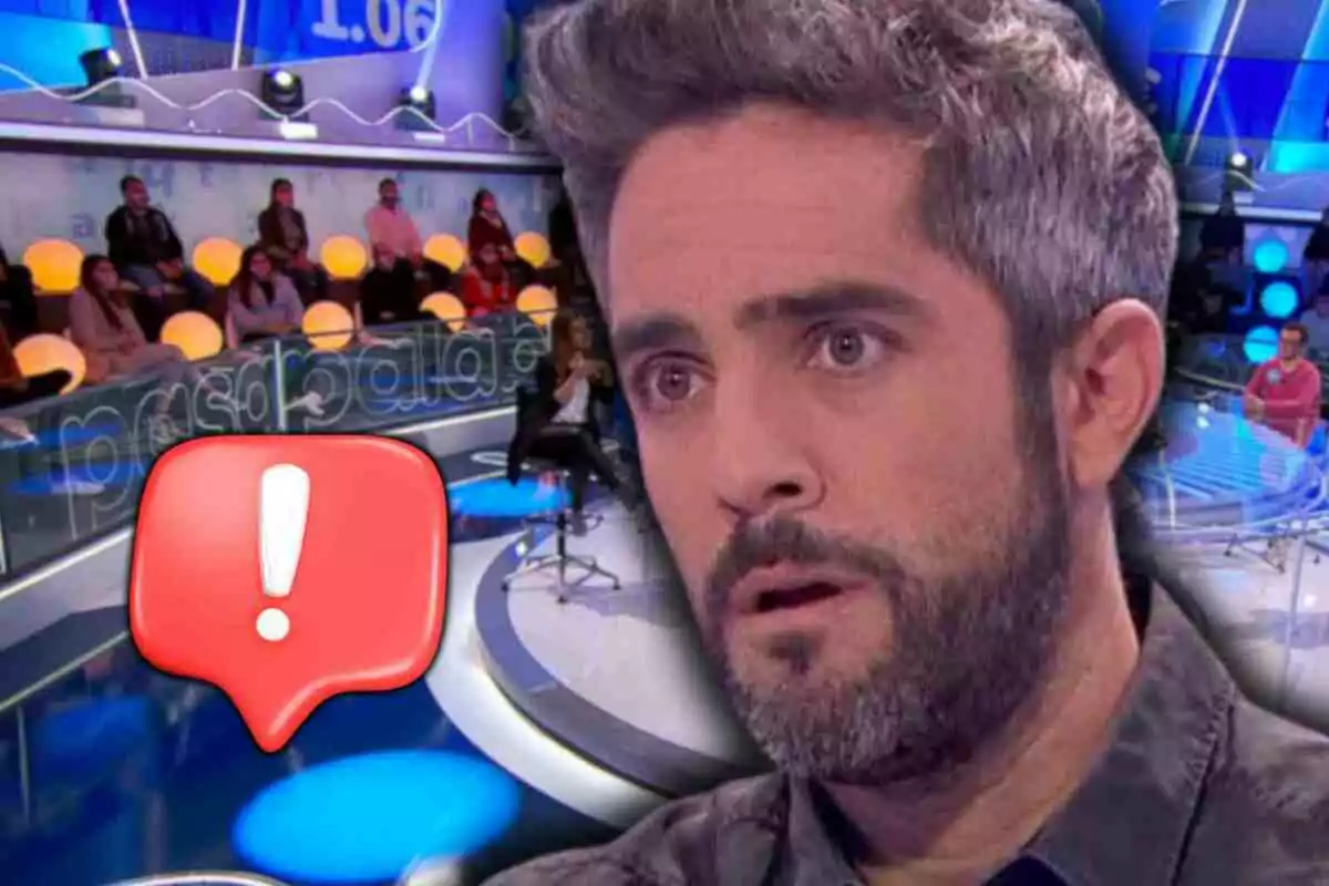 Roberto Leal with a surprised expression on 'Pasapalabra' with an audience and a red warning icon in the foreground