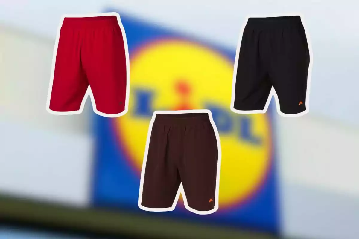 Tres pantalons curts esportius de color vermell, negre i marró sobre un fons desenfocat amb el logotip de Lidl Tres pantalons curts esportius de color vermell, negre i marró sobre un fons desenfocat amb el logotip de Lidl