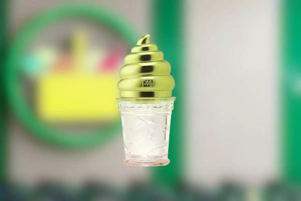 Envàs de perfum amb forma de cucurutxo de gelat amb tapa daurada i fons desenfocat Envàs de perfum amb forma de cucurutxo de gelat amb tapa daurada i fons desenfocat