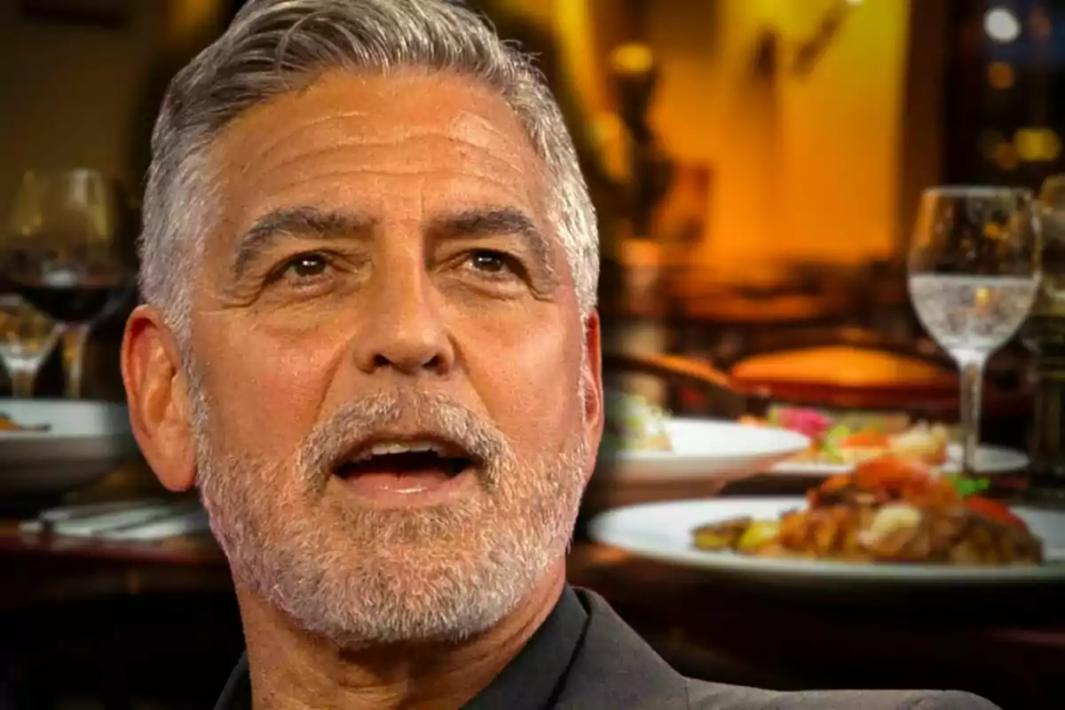 George Clooney en primer pla amb un fons de restaurant elegant i plats de menjar servits a la taula