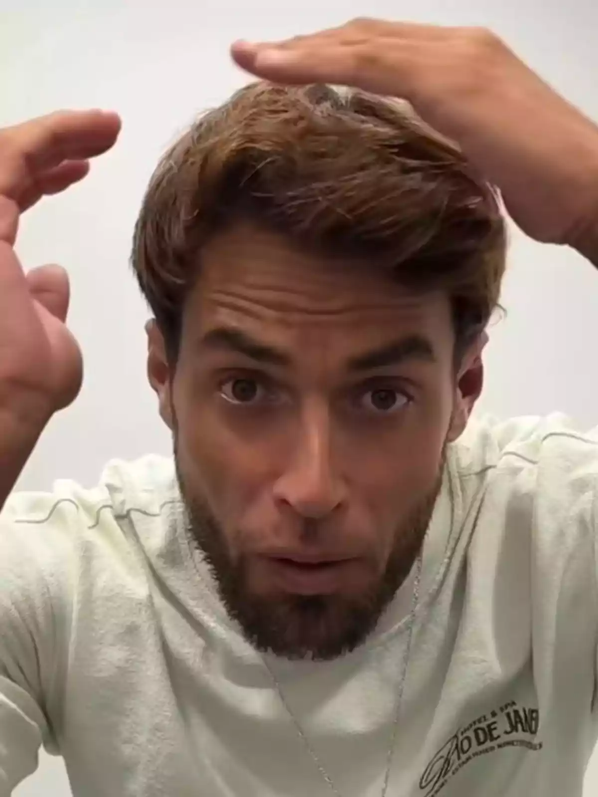Montoya with a beard and light brown hair looking at the camera while holding both hands on his head Montoya with a beard and light brown hair looking at the camera while holding both hands on his head