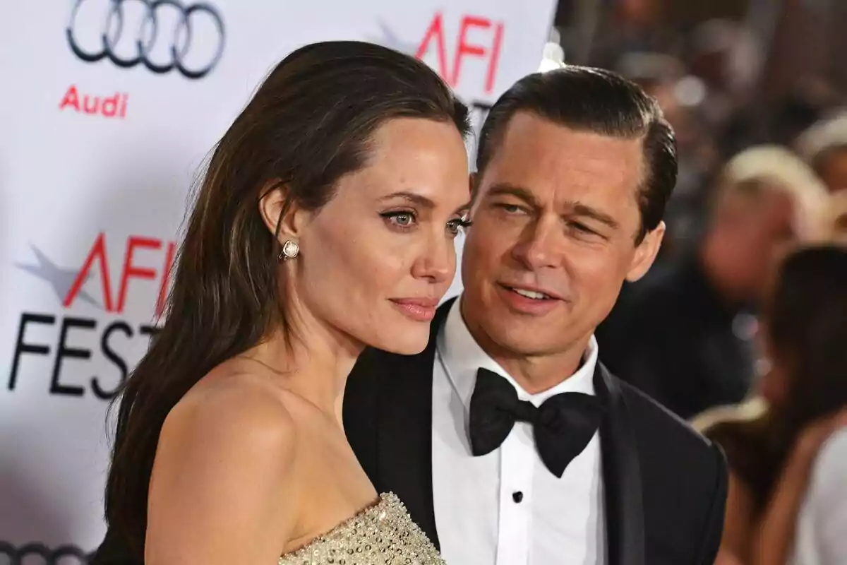 Una parella elegantment vestida, formada per Brad Pitt i Angelina Jolie, posa en una catifa vermella durant un esdeveniment de gala. Una parella elegantment vestida, formada per Brad Pitt i Angelina Jolie, posa en una catifa vermella durant un esdeveniment de gala.