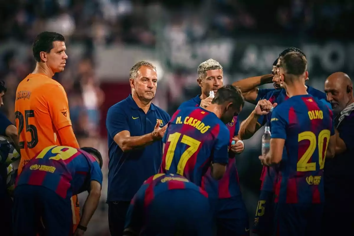 Jugadores de fútbol con uniforme azul y rojo escuchan indicaciones de su entrenador durante una pausa en el partido Jugadores de fútbol con uniforme azul y rojo escuchan indicaciones de su entrenador durante una pausa en el partido