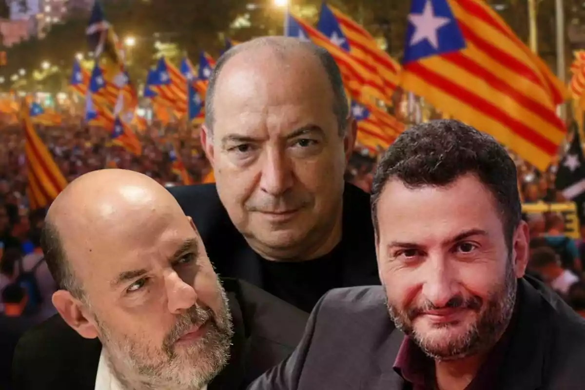 Tres homes en primer pla amb expressió seriosa i al fons una multitud onejant banderes estelades catalanes