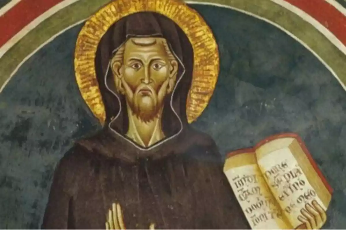 Pintura religiosa d’un home amb halo daurat vestit amb una túnica fosca sostenint un llibre obert amb inscripcions Pintura religiosa d’un home amb halo daurat vestit amb una túnica fosca sostenint un llibre obert amb inscripcions