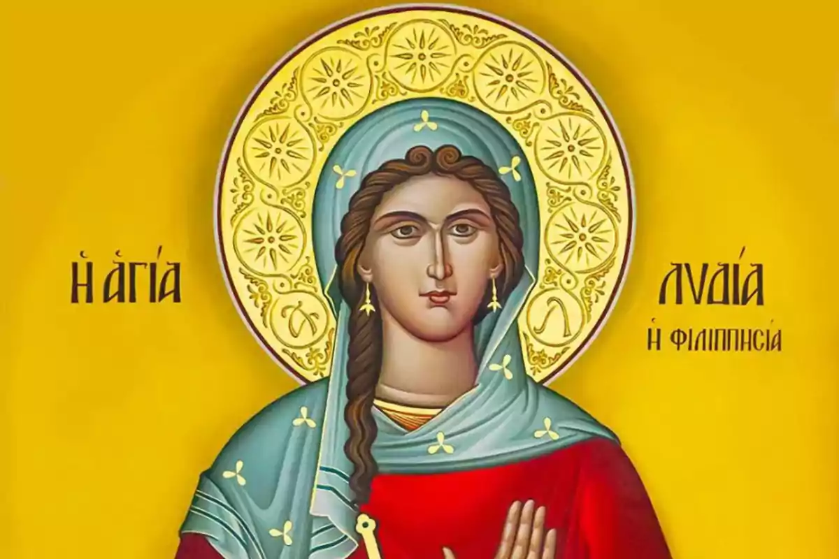 Icona religiosa d’una dona amb mantell blau i túnica vermella sobre fons groc amb aurèola daurada decorada i lletres en grec als costats Icona religiosa d’una dona amb mantell blau i túnica vermella sobre fons groc amb aurèola daurada decorada i lletres en grec als costats