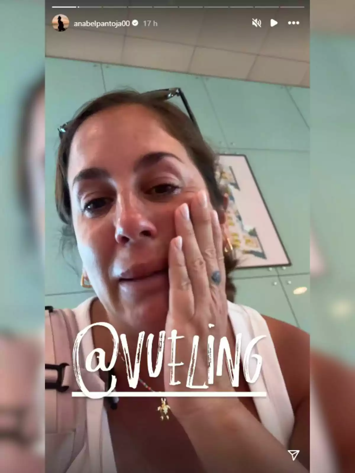 Anabel Pantoja amb expressió trista recolzant la mà a la galta, porta ulleres al cap i un top blanc, amb el text @vueling en gran sobre la imatge. Anabel Pantoja amb expressió trista recolzant la mà a la galta, porta ulleres al cap i un top blanc, amb el text @vueling en gran sobre la imatge.
