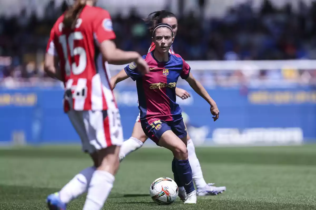 Jugadora del Barcelona femenino controla el balón durante un partido contra el Athletic Club en un estadio al aire libre Jugadora del Barcelona femenino controla el balón durante un partido contra el Athletic Club en un estadio al aire libre