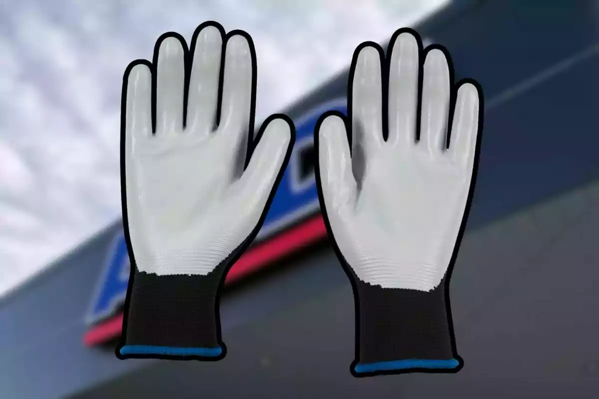 Par de guantes de trabajo blancos con puño negro y azul sobre un fondo desenfocado. Par de guantes de trabajo blancos con puño negro y azul sobre un fondo desenfocado.
