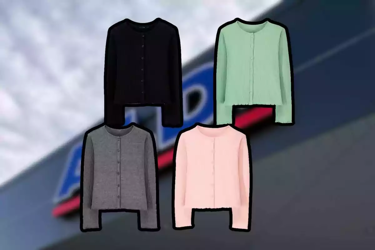 Quatre jerseis de punt en colors negre, verd, gris i rosa sobre un fons desenfocat d’una botiga Quatre jerseis de punt en colors negre, verd, gris i rosa sobre un fons desenfocat d’una botiga