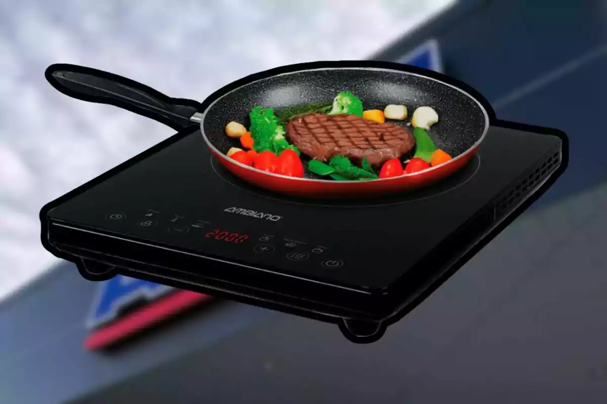 Sartén con carne y verduras sobre una estufa de inducción negra con controles digitales Sartén con carne y verduras sobre una estufa de inducción negra con controles digitales