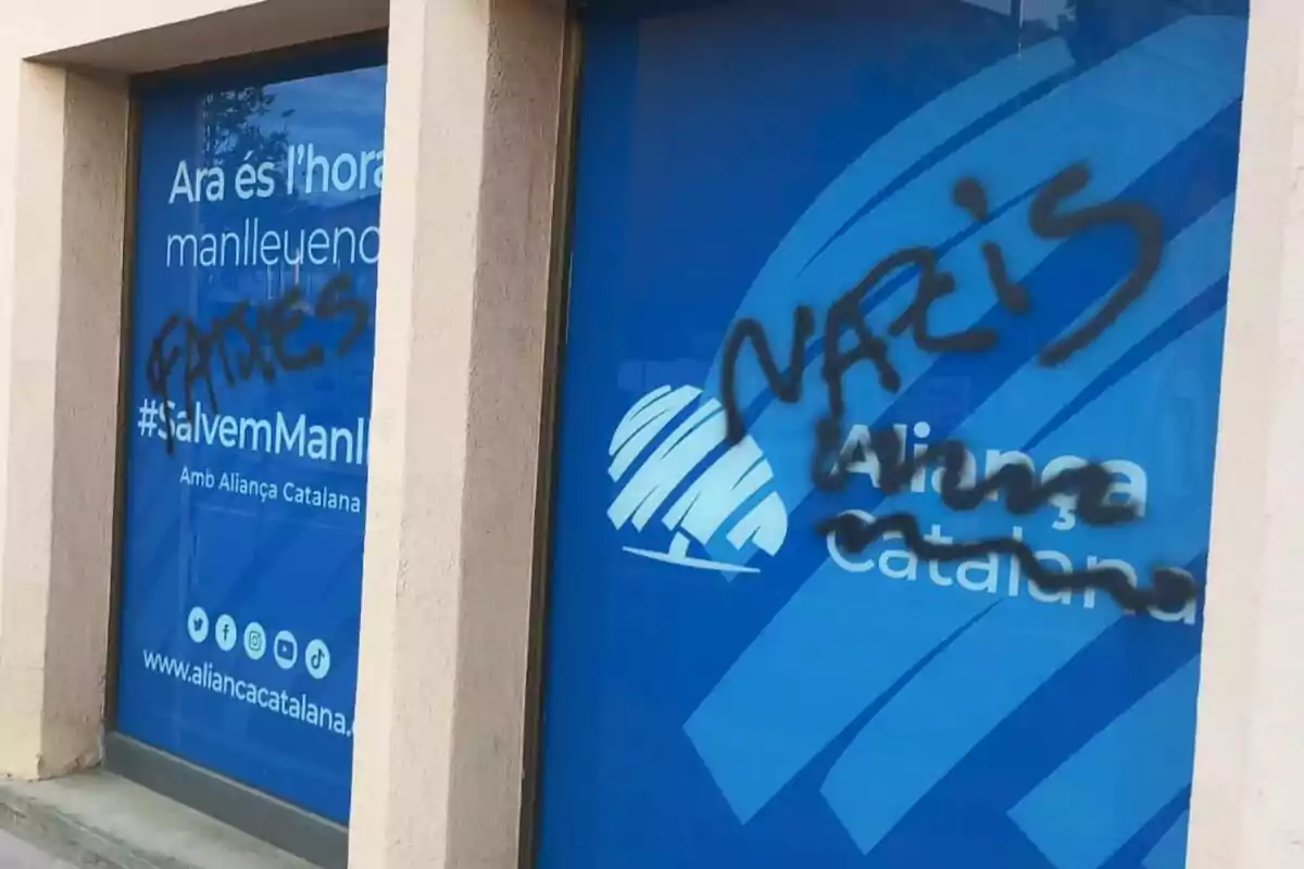 Ventanas de una sede de Aliança Catalana con pintadas en aerosol negro que dicen fatxes y nazis