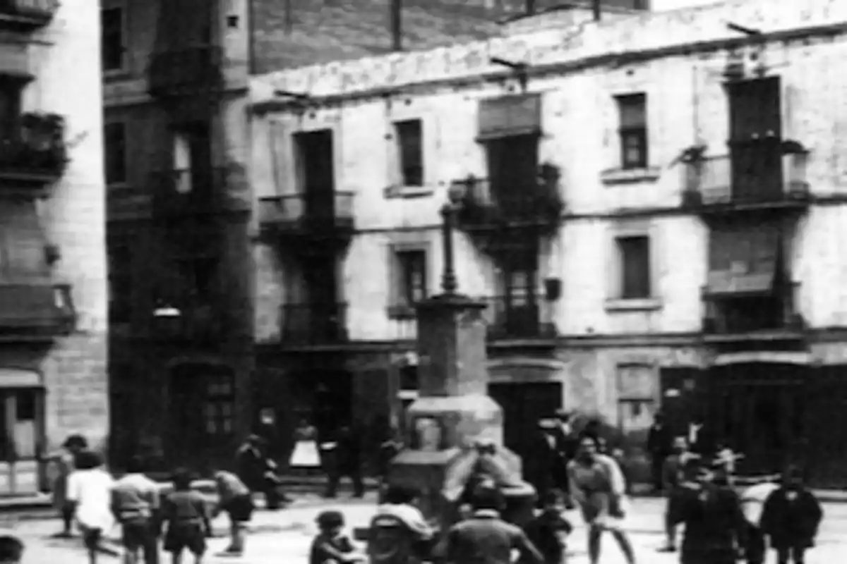 Personas caminando y niños jugando en una plaza antigua rodeada de edificios con balcones Personas caminando y niños jugando en una plaza antigua rodeada de edificios con balcones