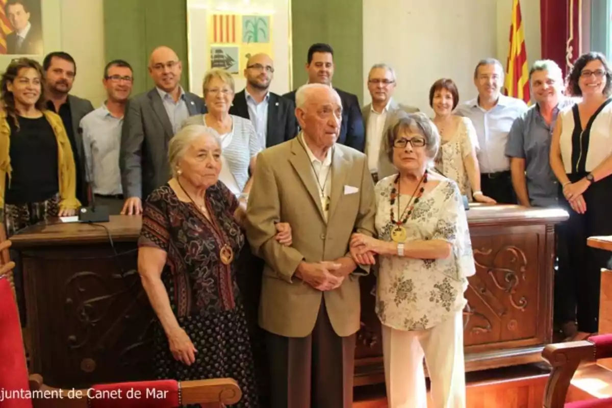 Un grupo de personas posando en una sala con decoración institucional y una bandera catalana al fondo Un grupo de personas posando en una sala con decoración institucional y una bandera catalana al fondo
