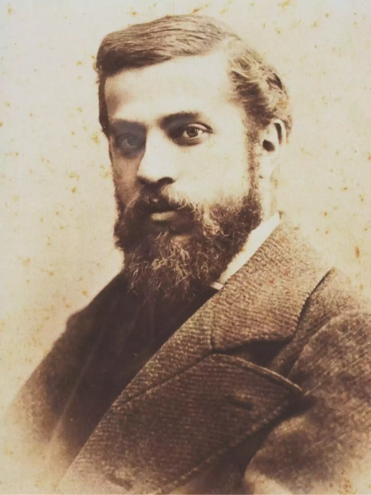 Retrato antiguo de un hombre con barba y bigote, vestido con saco y mirando hacia la cámara Retrato antiguo de un hombre con barba y bigote, vestido con saco y mirando hacia la cámara
